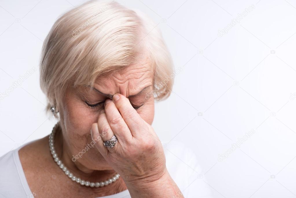 Elderly lady touching her head