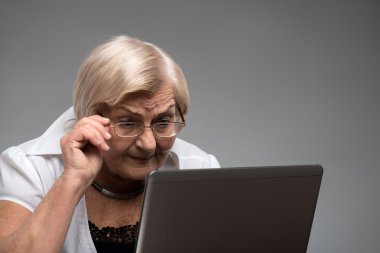 Belgili tanımlık laptop tutan yaşlı kadın