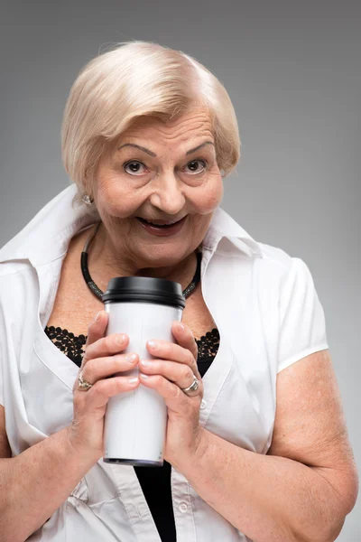 Elderly woman holding thermos cup — Stock Photo, Image