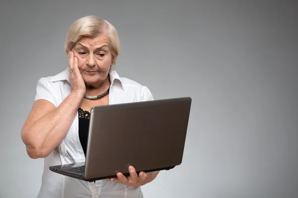Femme âgée tenant l'ordinateur portable — Photo
