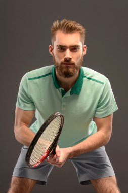 Genç adam tenis oynuyor.
