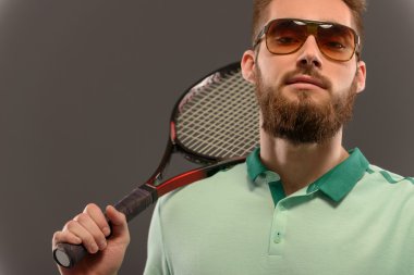 Genç adam tenis oynuyor.