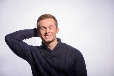 Mutlu genç adam eliyle başını ötesinde