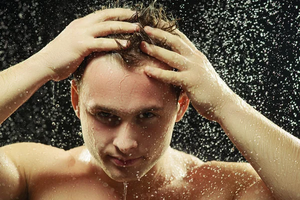 Pohledný mladý muž ve sprše — Stock fotografie