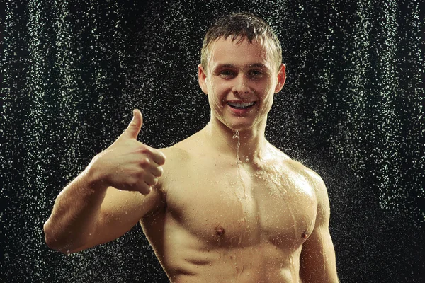 Schöner junger Mann, der eine Dusche nimmt — Stockfoto