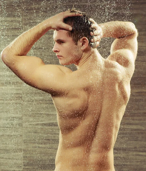 Knappe jonge man die een douche nemen — Stockfoto