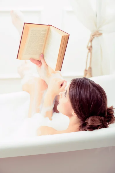 Kobieta w kąpieli z książką — Zdjęcie stockowe