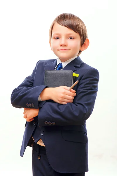 Деловой ребенок в костюме и галстуке позирует с блокнотом — стоковое фото