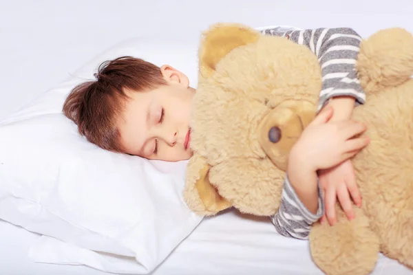 Retrato de un niño durmiendo con un osito de peluche — Foto de Stock