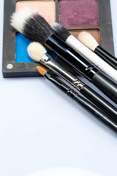 Set of makeup brushes on eye shadow palette — Stock Photo, Image