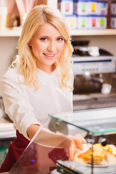 Beautiful young saleswoman in a bakery — Stock Photo, Image