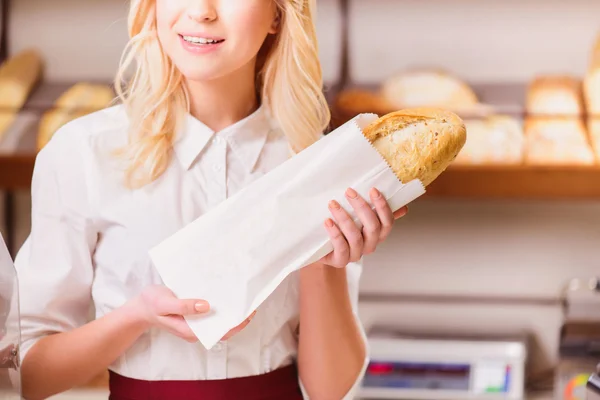 Mooie jonge winkelbediende in een bakkerij — Stockfoto