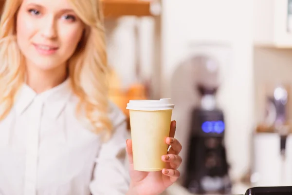 Baker sträcker ut ett papper kopp — Stockfoto