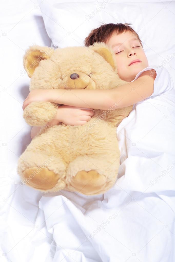 Portrait of a boy sleeping with teddy bear