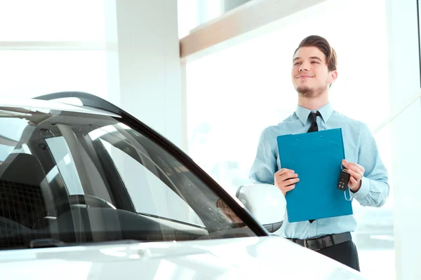 Handsome young man in dealership — Stock Photo, Image