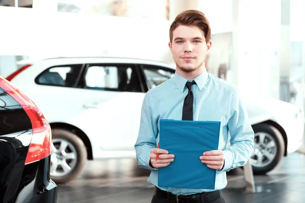 Handsome young man in dealership — Stock Photo, Image