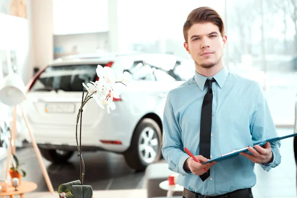 Handsome young man in dealership — Stock Photo, Image