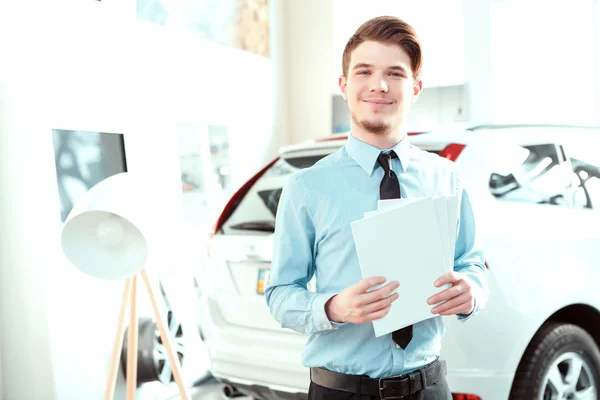 Handsome young man in dealership — Stock Photo, Image