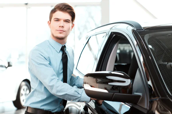 Handsome young man in dealership — Stock Photo, Image
