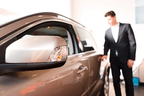 Schöner junger Mann im Autohaus — Stockfoto