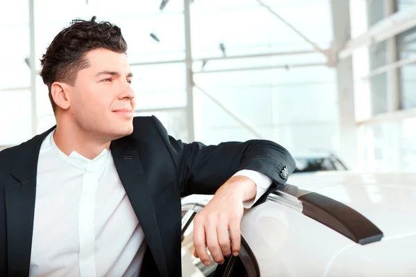 Handsome young man in dealership — Stock Photo, Image