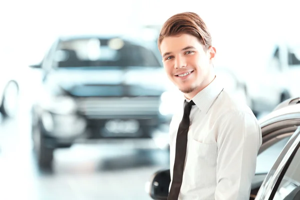 Handsome young man in dealership — Stock Photo, Image