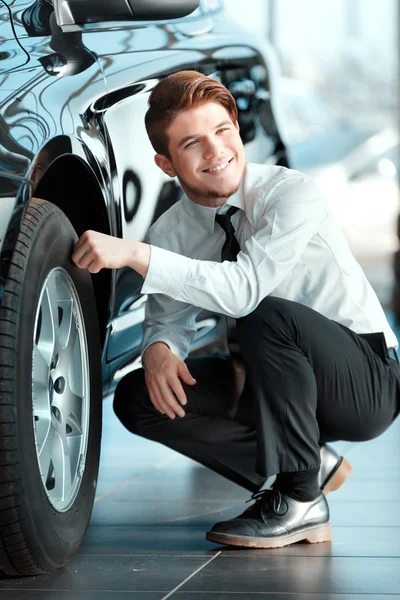 Schöner junger Mann im Autohaus — Stockfoto