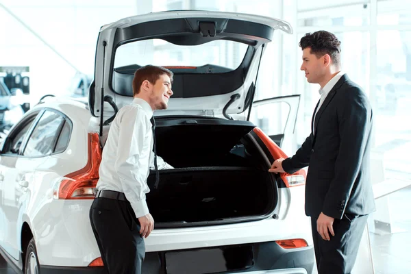 Handsome young man in dealership — Stock Photo, Image