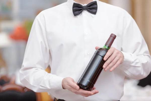 Serveur olding une bouteille de vin — Photo