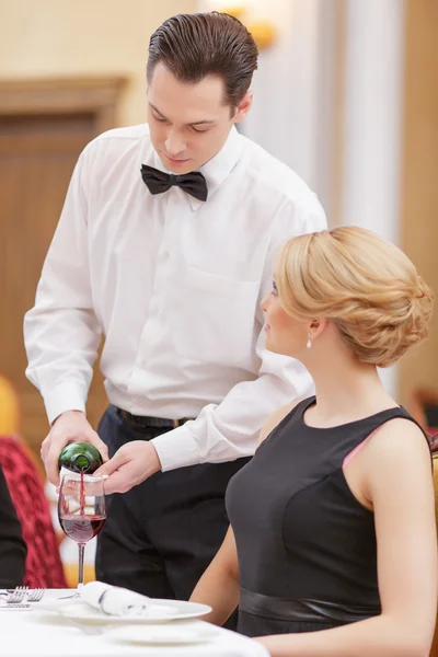 Camarero sirviendo vino a su hermosa clienta —  Fotos de Stock