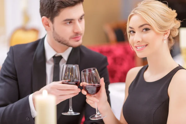 Casal jovem bebendo vinho no restaurante — Fotografia de Stock