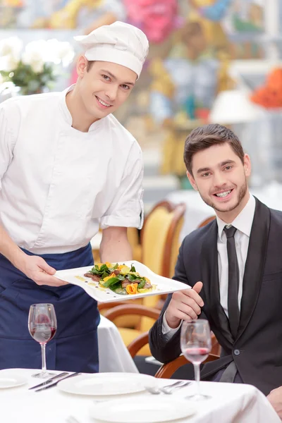 Koch serviert Salat an gutaussehende Kundin — Stockfoto