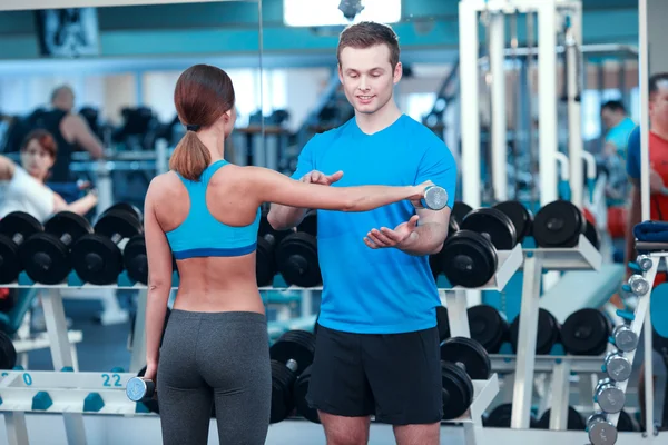 Mooi meisje in sportclub met instructeur — Stockfoto