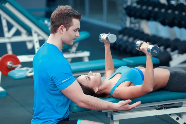 Hermosa chica en el club deportivo con instructor — Foto de Stock