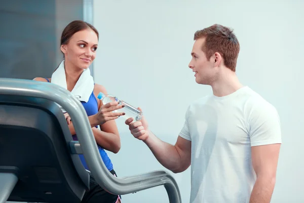 Hermosa chica en el club deportivo con instructor — Foto de Stock