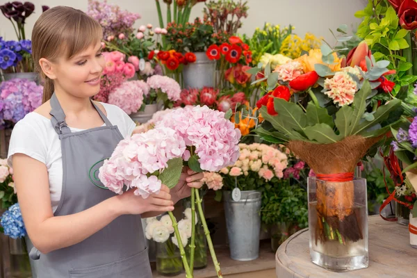 Florista coloca buquê no vaso — Fotografia de Stock