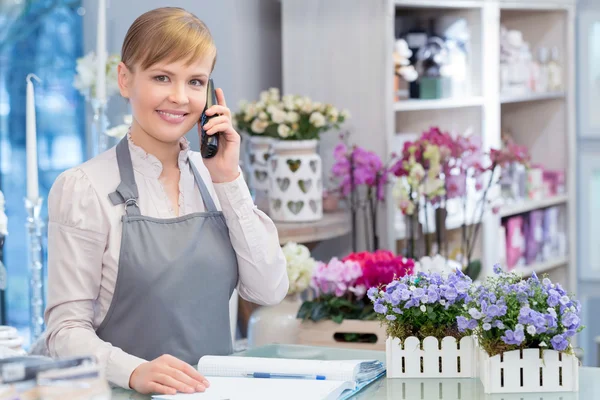 Young florist talks over the phone — Stock Photo, Image