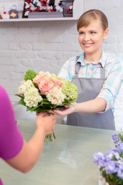 Florist gives a bouquet to the client — Stock Photo, Image