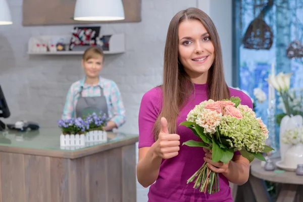 Frau mit Blumenstrauß hebt den Daumen — Stockfoto