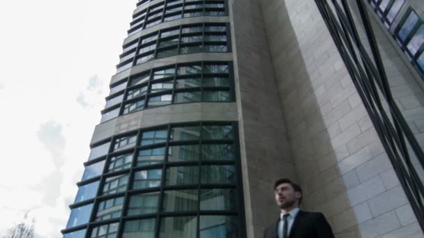 Businessman standing by the skyscraper — Stock Video