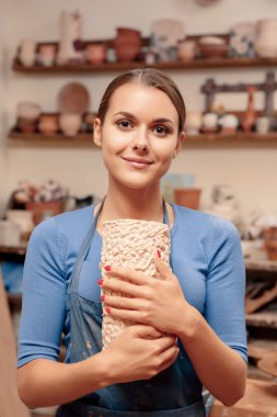 Kadın bir vazo onun elinde tutar.