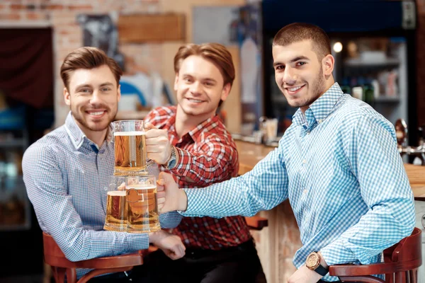 Друзья пьют пиво в пабе. — стоковое фото