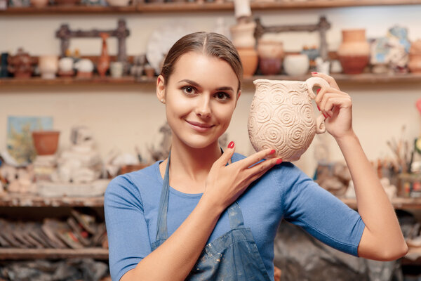 Girl holds a clay jar