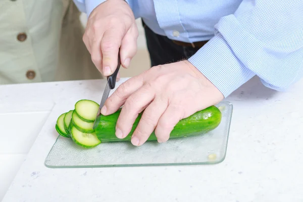 Adam mutfakta salatalık keser — Stok fotoğraf