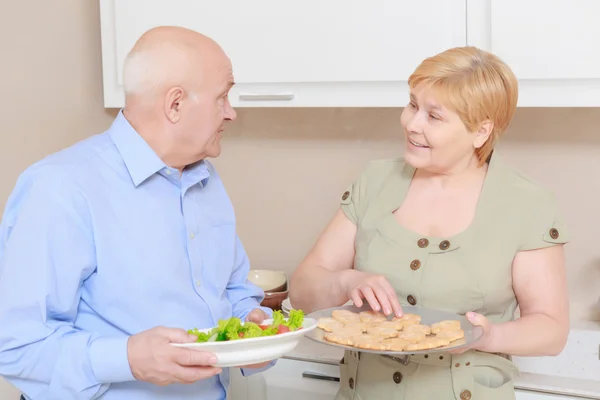 Casal segura um prato com salada — Fotografia de Stock