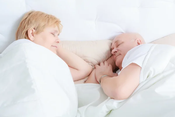 Elderly couple asleep in bed — Stock Photo, Image