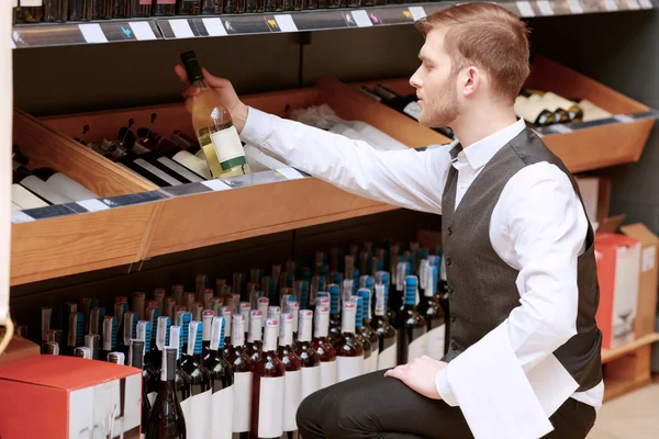 Sommelier i butik nära hyllor — Stockfoto