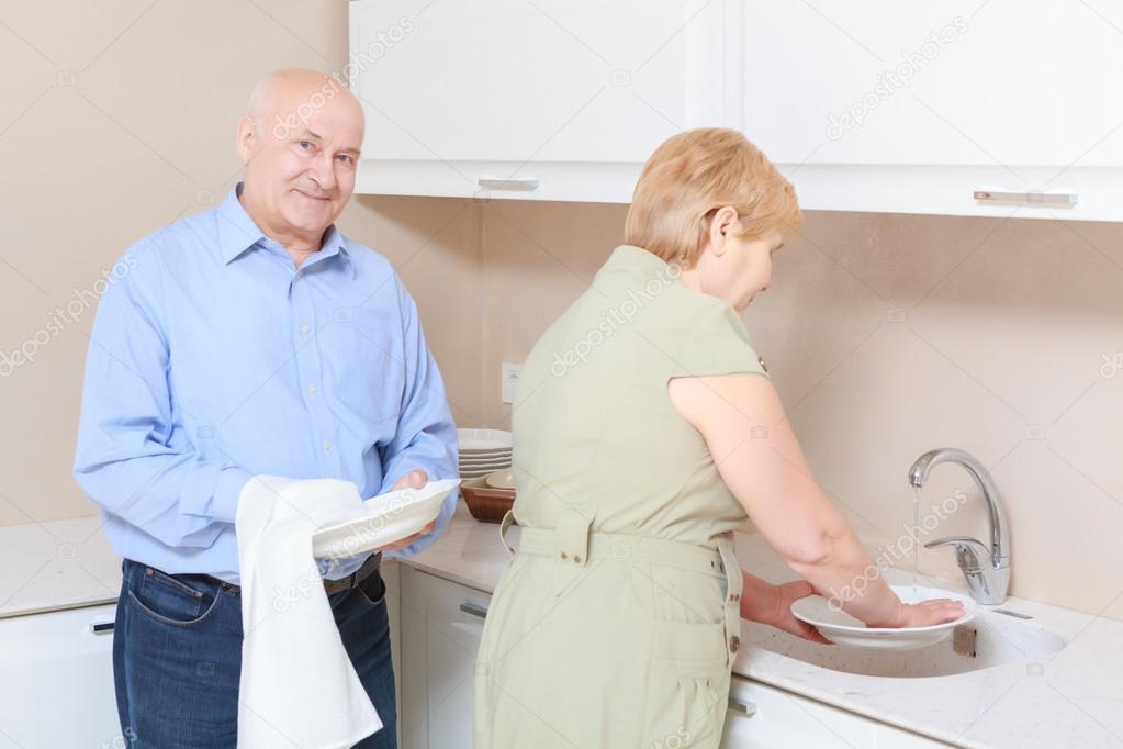 Couple washes dishes in the kitchen