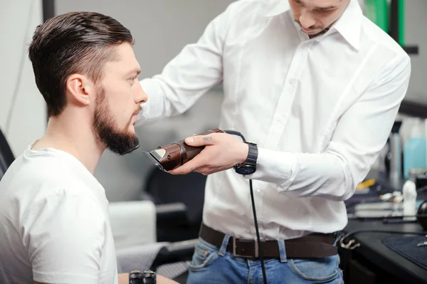 Mężczyzna goli brodę z maszynka do strzyżenia — Zdjęcie stockowe