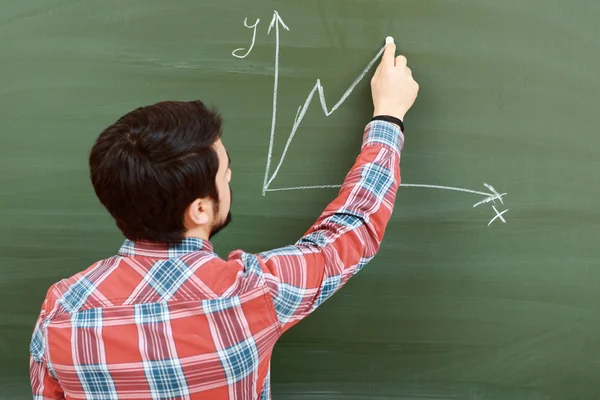 Student draws graph on blackboard — Stock Photo, Image